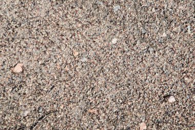 Küçük taşlar ve parlak mineral parçalarıyla doğal desenli çakıl yüzeyine yakın çekim