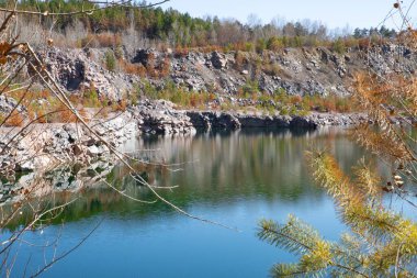 Sakin derin mavi su ve orman yansıması ile uçurum kenarında göl