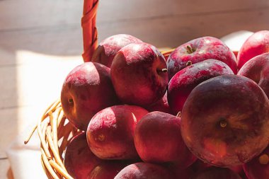 Sepette kırmızı elmalar, dantel torbada lavanta güneş ışığında ahşap zemin, sade sonbahar hayatı