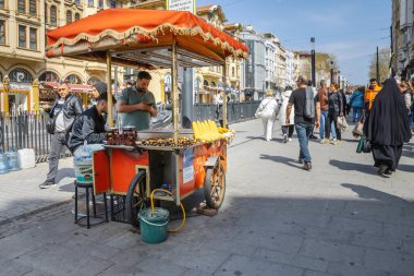 İstanbul 'un merkezinde 6 Nisan 2025' te mısır ve kestane kızartan sokak satıcısı.