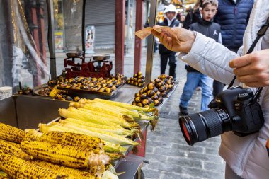 İstanbul 'un merkezinde 6 Nisan 2025' te mısır ve kestane kızartan sokak satıcısı.