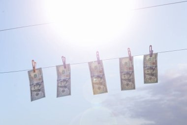 Çamaşır ipinde mandallarla asılı Amerikan Doları Faturaları. Kara para aklama, finans ve ekonomi kavramı. Sadece Düzenleyici Kullan.