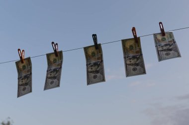 Çamaşır ipinde mandallarla asılı Amerikan Doları Faturaları. Kara para aklama, finans ve ekonomi kavramı. Sadece Düzenleyici Kullan.