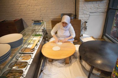 İstanbul Restoranı 'nda Geleneksel Türk Kadını Düz Ekmek Hazırlıyor. Otantik Mutfak Süreci ve Türk Kültürü. 10 Nisan 2025. Sadece Düzenleyici Kullan.
