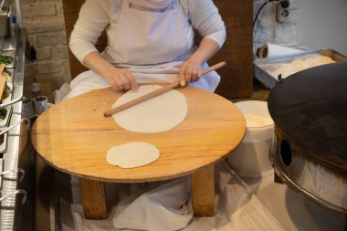 İstanbul Restoranı 'nda Geleneksel Türk Kadını Düz Ekmek Hazırlıyor. Otantik Mutfak Süreci ve Türk Kültürü. 10 Nisan 2025. Sadece Düzenleyici Kullan.
