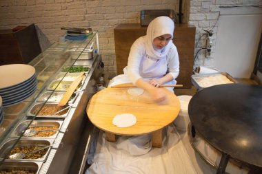 İstanbul Restoranı 'nda Geleneksel Türk Kadını Düz Ekmek Hazırlıyor. Otantik Mutfak Süreci ve Türk Kültürü. 10 Nisan 2025. Sadece Düzenleyici Kullan.