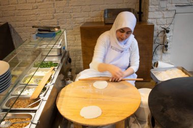 İstanbul Restoranı 'nda Geleneksel Türk Kadını Düz Ekmek Hazırlıyor. Otantik Mutfak Süreci ve Türk Kültürü. 10 Nisan 2025. Sadece Düzenleyici Kullan.