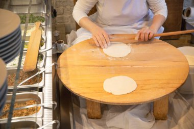 İstanbul Restoranı 'nda Geleneksel Türk Kadını Düz Ekmek Hazırlıyor. Otantik Mutfak Süreci ve Türk Kültürü. 10 Nisan 2025. Sadece Düzenleyici Kullan.