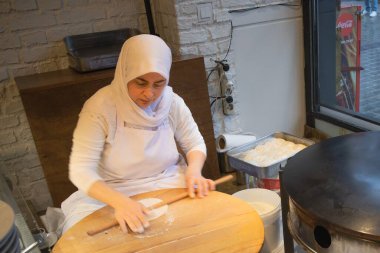 İstanbul Restoranı 'nda Geleneksel Türk Kadını Düz Ekmek Hazırlıyor. Otantik Mutfak Süreci ve Türk Kültürü. 10 Nisan 2025. Sadece Düzenleyici Kullan.