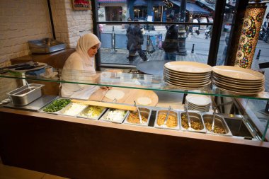 İstanbul Restoranı 'nda Geleneksel Türk Kadını Düz Ekmek Hazırlıyor. Otantik Mutfak Süreci ve Türk Kültürü. 10 Nisan 2025. Sadece Düzenleyici Kullan.