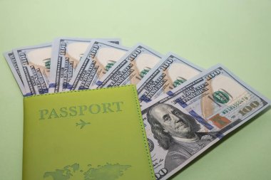 Fotokopi alanı ve seyahat bütçesi kavramına sahip yeşil arka plan için Amerikan doları içeren pasaport
