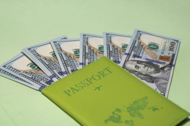 Fotokopi alanı ve seyahat bütçesi kavramına sahip yeşil arka plan için Amerikan doları içeren pasaport