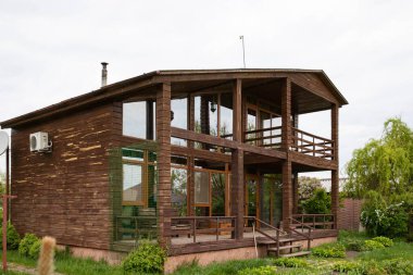 Ağaçlı kır evi ve doğal çevrede yeşil çalılıklar, satılık emlak.