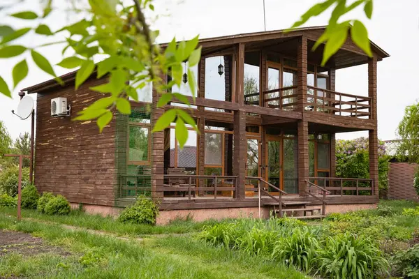 Ağaçlı kır evi ve doğal çevrede yeşil çalılıklar, satılık emlak.