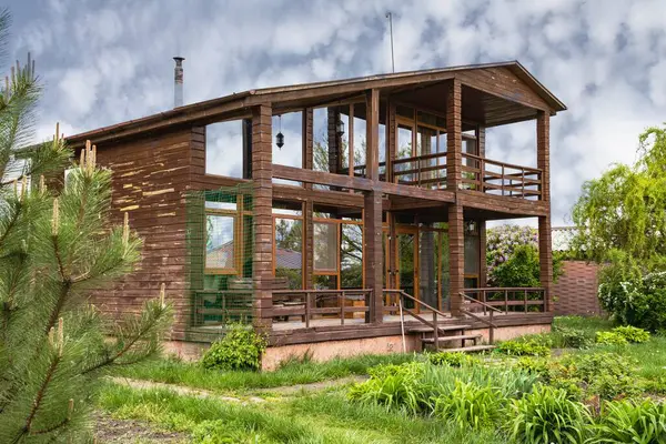 Ağaçlı kır evi ve doğal çevrede yeşil çalılıklar, satılık emlak.