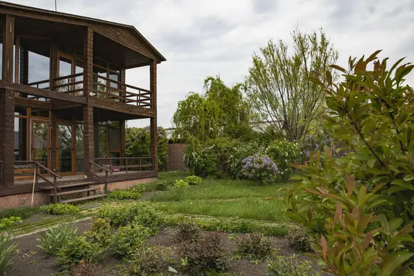 Ağaçlı kır evi ve doğal çevrede yeşil çalılıklar, satılık emlak.