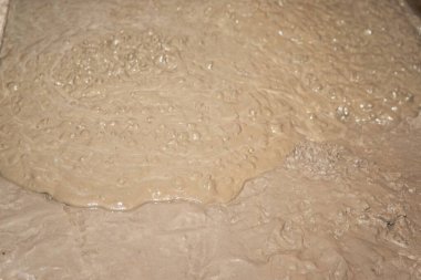 Yüzeyde akan bej ıslak beton dokunun yakın çekimi