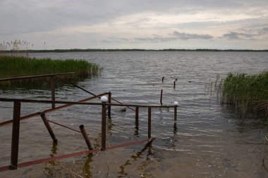 Fırtına, yıkım ve doğal afet kavramı, göldeki kırık ahşap iskele.