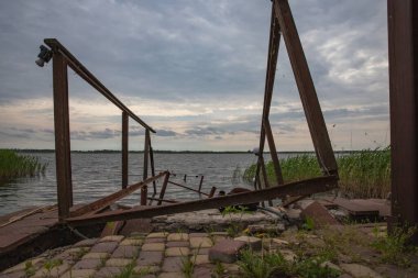 Fırtına, yıkım ve doğal afet kavramı, göldeki kırık ahşap iskele.