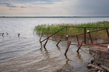 Fırtına, yıkım ve doğal afet kavramı, göldeki kırık ahşap iskele.