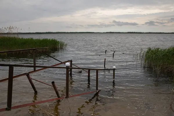 Fırtına, yıkım ve doğal afet kavramı, göldeki kırık ahşap iskele.
