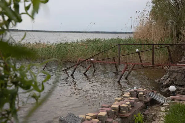 Fırtına, yıkım ve doğal afet kavramı, göldeki kırık ahşap iskele.
