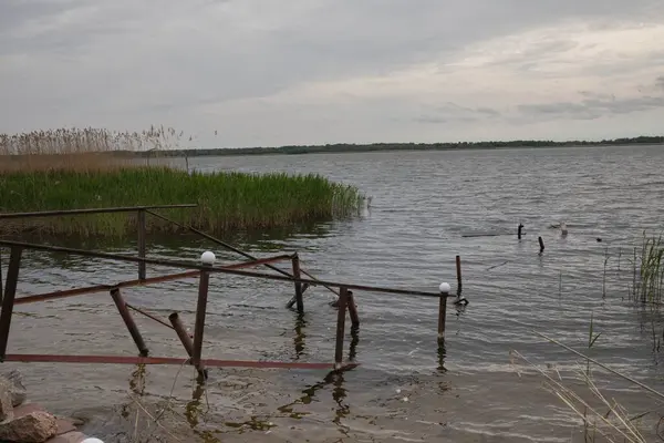 Fırtına, yıkım ve doğal afet kavramı, göldeki kırık ahşap iskele.