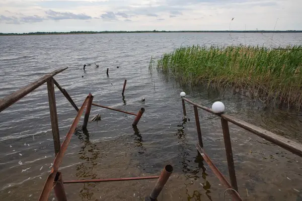 Fırtına, yıkım ve doğal afet kavramı, göldeki kırık ahşap iskele.