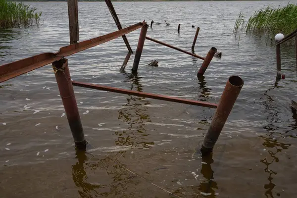 Fırtına, yıkım ve doğal afet kavramı, göldeki kırık ahşap iskele.