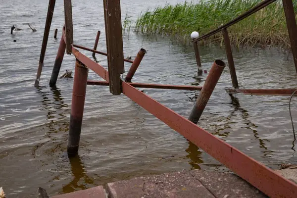Fırtına, yıkım ve doğal afet kavramı, göldeki kırık ahşap iskele.