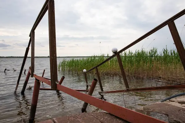 Fırtına, yıkım ve doğal afet kavramı, göldeki kırık ahşap iskele.