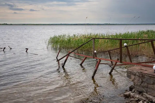 Fırtına, yıkım ve doğal afet kavramı, göldeki kırık ahşap iskele.
