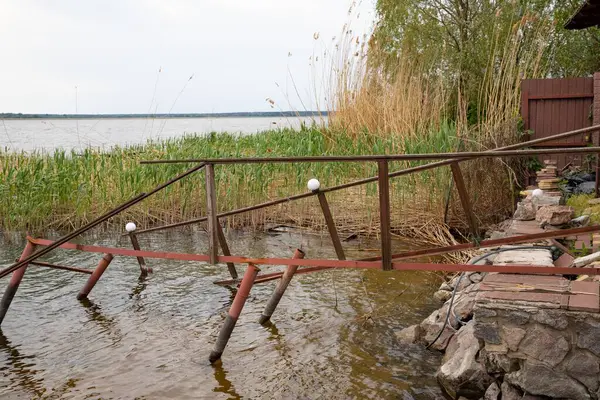 Fırtına, yıkım ve doğal afet kavramı, göldeki kırık ahşap iskele.