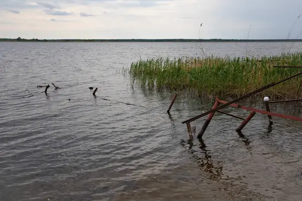 Fırtına, yıkım ve doğal afet kavramı, göldeki kırık ahşap iskele.