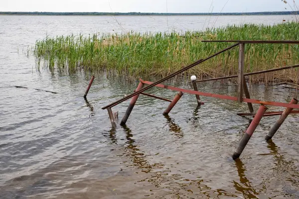 Fırtına, yıkım ve doğal afet kavramı, göldeki kırık ahşap iskele.