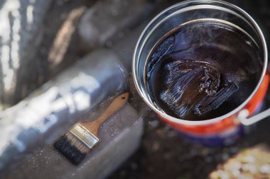 Metal bir tencerede dumanlı katran ya da reçine pişirmek