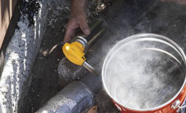 Metal bir tencerede dumanlı katran ya da reçine pişirmek