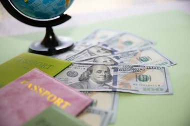 Dolar banknotları, renkli pasaportlar ve küreyle seyahat kavramı