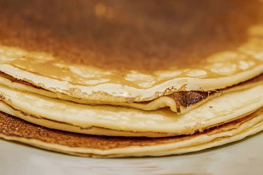 Seramik tabakta altın kahverengi krep yığını, ev yapımı kahvaltı konsepti.