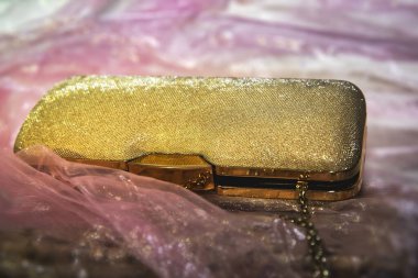 Pembe saten kumaş aksesuar üzerinde zarif altın debriyaj