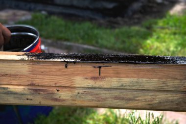 Açık bir teneke üzerinde siyah boyaya batırılmış el fırçası.