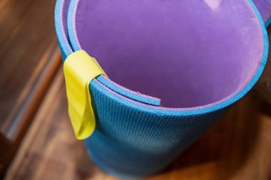 Sarı direniş bandıyla sarılmış yoga minderi.