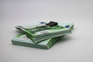 Beyaz arkaplanda ciltlenmiş 100 Euro 'luk banknot yığınları