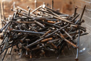 Güneş ışığı, inşaat ve onarım konseptinde karton yüzeyde siyah vidalar yığını