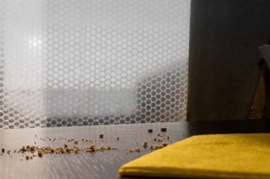 Sarı temizlik bezi ve siyah ahşap masadaki kırıntılar, ev temizliği kavramı.
