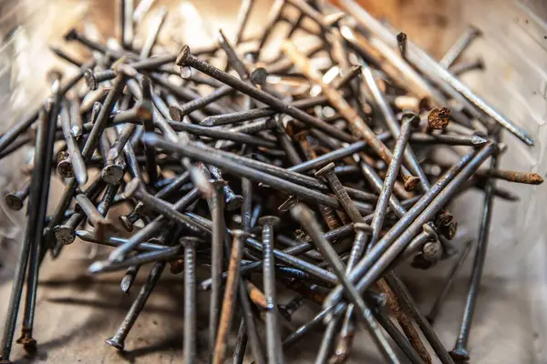 Güneş ışığı, inşaat ve onarım konseptinde karton yüzeyde siyah vidalar yığını