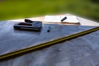 OSB panelinde plastik kaplamalı zımba ve mezura.