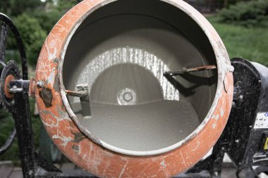Eski turuncu çimento karıştırıcısında kuru beton ve açık hava inşaat malzemeleri var.