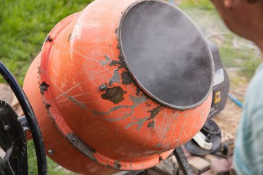 Eski turuncu çimento karıştırıcısında kuru beton ve açık hava inşaat malzemeleri var.