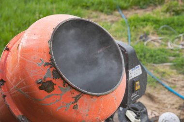 Eski turuncu çimento karıştırıcısında kuru beton ve açık hava inşaat malzemeleri var.